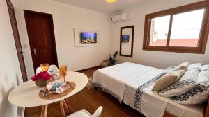 a small bedroom with a bed and a table with drinks at Casa da Praia Pousada in Torres