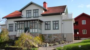 a large white house with a red house at Prästgårdens Pensionat in Mollösund