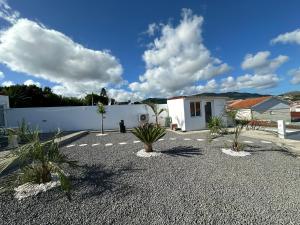 ein Innenhof mit Palmen und einem weißen Zaun in der Unterkunft Casa Terra Mar in Angra do Heroísmo