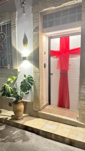 una porta con un fiocco rosso sopra e una pianta di IL BACIO DEL SOLE a Noto