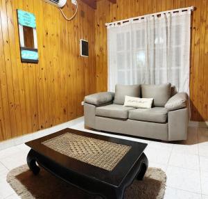 a living room with a couch and a coffee table at Hermosa casa en Country Rincon Ituzaingo in Ituzaingó