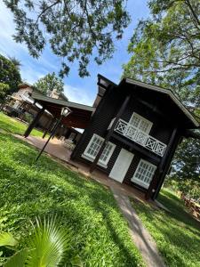 a black house with white windows and a yard at Hermosa casa en Country Rincon Ituzaingo in Ituzaingó