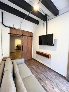 a living room with a couch and a tv on a wall at Eonia in Atlixco