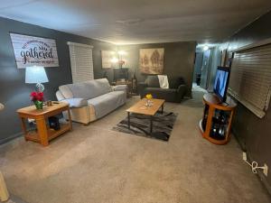 a living room with a couch and a tv at USS Clarkston Home in Willie Run Airport