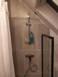 ein Bad mit einer Dusche mit einer Flasche an der Wand in der Unterkunft Hébergement Cozy à Deville-lès-Rouen - 13 min Rouen in Déville-lès-Rouen