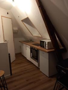 eine Küche mit einer Mikrowelle auf einer Theke im Dachgeschoss in der Unterkunft Hébergement Cozy à Deville-lès-Rouen - 13 min Rouen in Déville-lès-Rouen + 20 Fotos