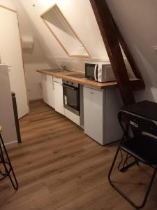 eine Küche mit einer Arbeitsfläche, auf der eine Mikrowelle steht in der Unterkunft Hébergement Cozy à Deville-lès-Rouen - 13 min Rouen in Déville-lès-Rouen