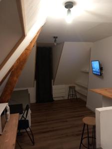 Zimmer im Dachgeschoss mit einer Treppe und einem TV in der Unterkunft Hébergement Cozy à Deville-lès-Rouen - 13 min Rouen in Déville-lès-Rouen