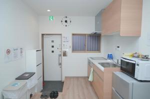 a small kitchen with a sink and a microwave at 天下茶屋駅1分シャワートイレ各階付き関西空港直通wifiあり in Osaka