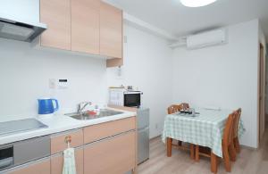 a kitchen with a sink and a table with chairs at 天下茶屋駅1分シャワートイレ各階付き関西空港直通wifiあり in Osaka +23 photos