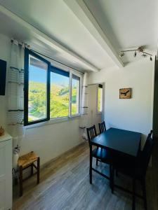 a dining room with a table and a large window at La Lauzière appartement au pied des pistes in Saint-François-Longchamp +3 photos