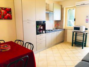 a kitchen with white cabinets and a table with a microwave at Marasusa Dreams in Parghelia