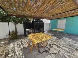 a patio with a wooden table and a grill at Departamento en Las Grutas in Las Grutas