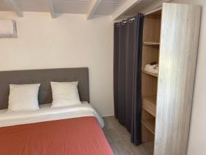 a small bedroom with a bed and a closet at Jardin Secret in Petit-Bourg