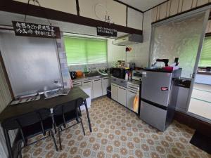 岩国市エフケーテックほったらかし宿的一间带柜台和冰箱的小厨房