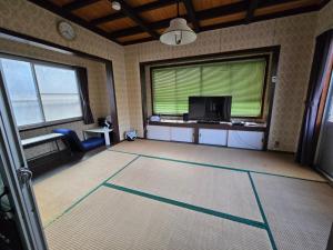 岩国市エフケーテックほったらかし宿的一间带电视和大窗户的客厅