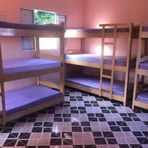 two bunk beds in a room with a checkered floor at Chácara Espelho D água in Vargem