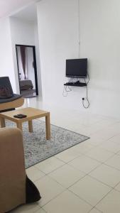 a living room with a table and a laptop in it at AMAN Homestay Senawang musliim only in Senawang +4 photos