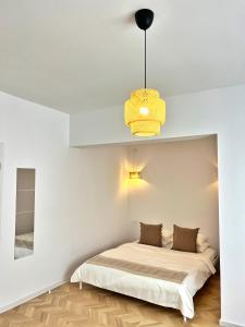 a bedroom with a bed and a pendant light at Tzatziki Boutique Rooms in Kavala