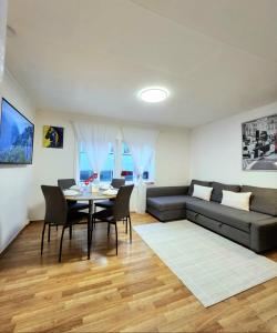 Una sala de estar con un sofá y una mesa con sillas. en Stavanger 1 Ultra Central Dali Apartament, en Stavanger