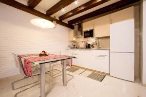 uma cozinha com uma mesa e um frigorífico em Moretta Apartment em Veneza