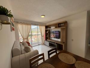 a living room with a couch and a tv and a table at Piso 11 con vista a la montaña, Callejuelas in Piedecuesta