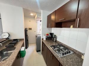 a kitchen with a sink and a stove top oven at Piso 11 con vista a la montaña, Callejuelas in Piedecuesta