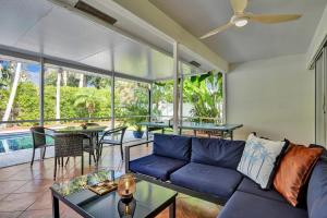 ein Wohnzimmer mit einem blauen Sofa und einem Tisch in der Unterkunft Coconut Clubhouse - Heated Pool - Hot tub - Ping Pong in Fort Lauderdale