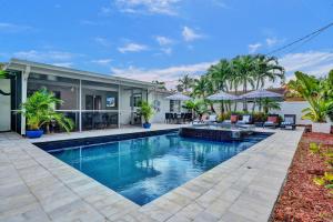 ein Swimmingpool vor einem Haus in der Unterkunft Coconut Clubhouse - Heated Pool - Hot tub - Ping Pong in Fort Lauderdale