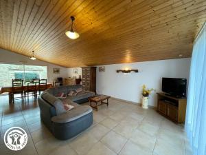 a living room with a couch and a tv at Charmante grange rénovée avec grand terrain, Wi-Fi, barbecue, proche ferme et nature - FR-1-426-131 in La Garnache
