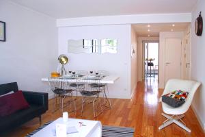 リスボンにあるALTIDO Modern 1-bed Apt with terrace, moments from São Bento Palaceのリビングルーム(ソファ、テーブル、椅子付)