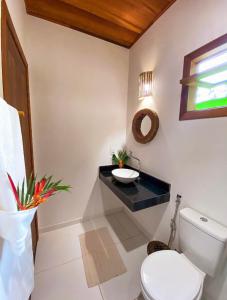 a bathroom with a toilet and a sink at Village da Mata Arraial in Porto Seguro