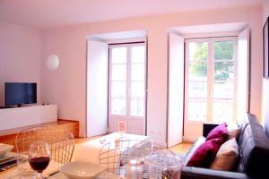 ein Wohnzimmer mit einem Sofa und einem Glastisch in der Unterkunft JOIVY Modern 1-bed Apt with terrace, moments from São Bento Palace in Lissabon