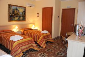 a hotel room with two beds and a television at L'Antica Dimora in San Pietro Vernotico