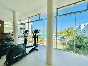 a gym with two treadmills and a view of the ocean at Lindo con gran alberca tipo playa by G P S rentas in Mazatlán