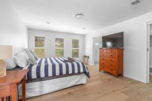 a bedroom with a bed and a dresser and a television at Riverleigh, Gerroa in Gerroa