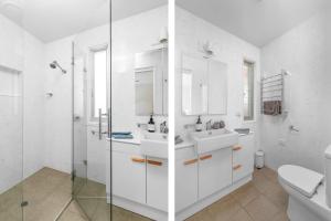 a white bathroom with two sinks and a shower at Riverleigh, Gerroa in Gerroa +26 photos