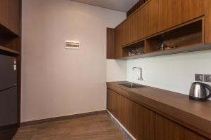a kitchen with wooden cabinets and a sink at Pondok Deamore Villa in Gianyar +5 photos