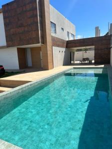 a large swimming pool in front of a building at Mansão Moraes - em Itacimirim Linha Verde in Camacari