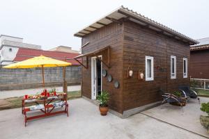 弗洛里亚诺波利斯Casa Perto das melhores praias Florianópolis, 8 pessoas, ar condicionado, tv, wifi, cozinha completa, lavanderia,的一间带桌子和雨伞的小房子