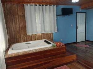 a bath tub in a room with a window at Vila do Vento in Lavras Novas