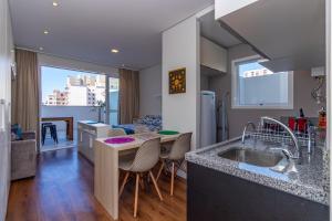 a kitchen and living room with a sink and a table at Mood Independência in Passo Fundo