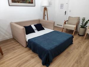 a bedroom with a bed and a couch and a chair at Apartamento a 500 metros da Praia do Forte in Cabo Frio