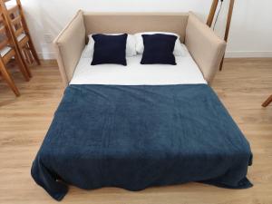 a bed with a blue blanket and pillows on it at Apartamento a 500 metros da Praia do Forte in Cabo Frio
