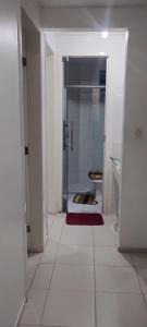 a white bathroom with a shower and a red rug at Condomínio São Francisco in Petrolina