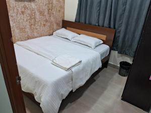 two beds in a room with white sheets and pillows at Hotel Oasisinn in Hyderabad