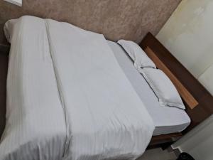 a bed with white sheets and pillows on it at Hotel Oasisinn in Hyderabad