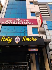 a sign for a holly smote restaurant in front of a building at Hotel Oasisinn in Hyderabad