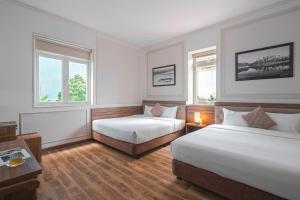 Postel nebo postele na pokoji v ubytování Dalat Roof Hotel
