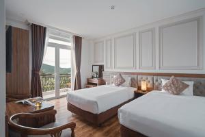 Postel nebo postele na pokoji v ubytování Dalat Roof Hotel